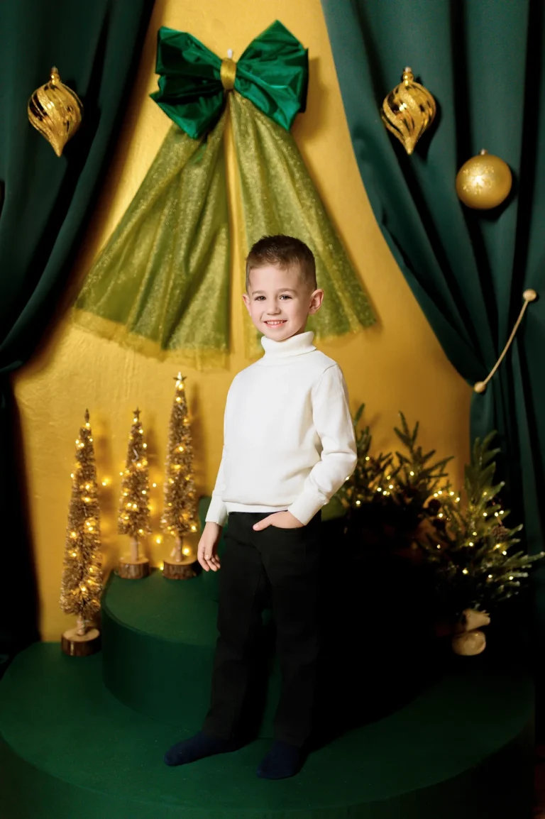 Bambino in camicia bianca su fondale dorato, ritratto natalizio in studio a Venaria Reale