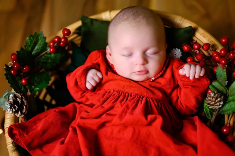 Neonata avvolta in una coperta rossa, foto newborn di Natale a Torino