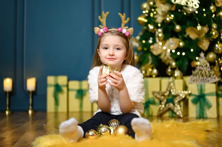 Bambina con cerchietto da renna davanti all’albero di Natale, servizio fotografico natalizio a Torino