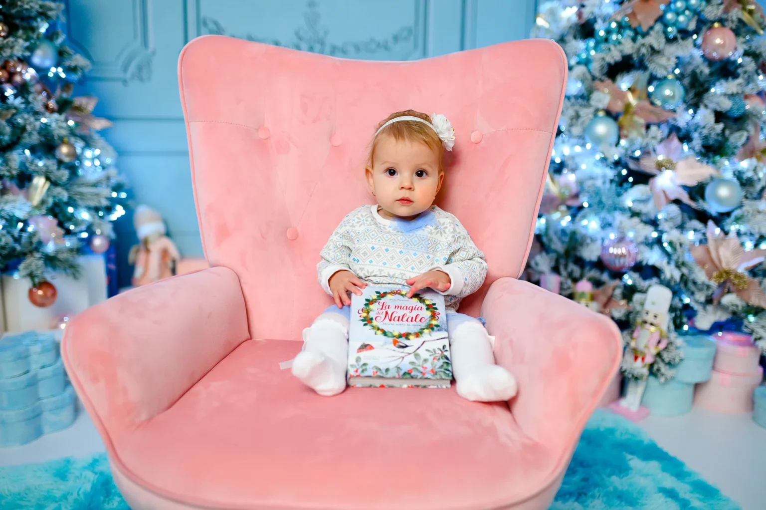 Bimba su una poltrona rosa accanto all’albero azzurro, foto di Natale in studio a Venaria Reale