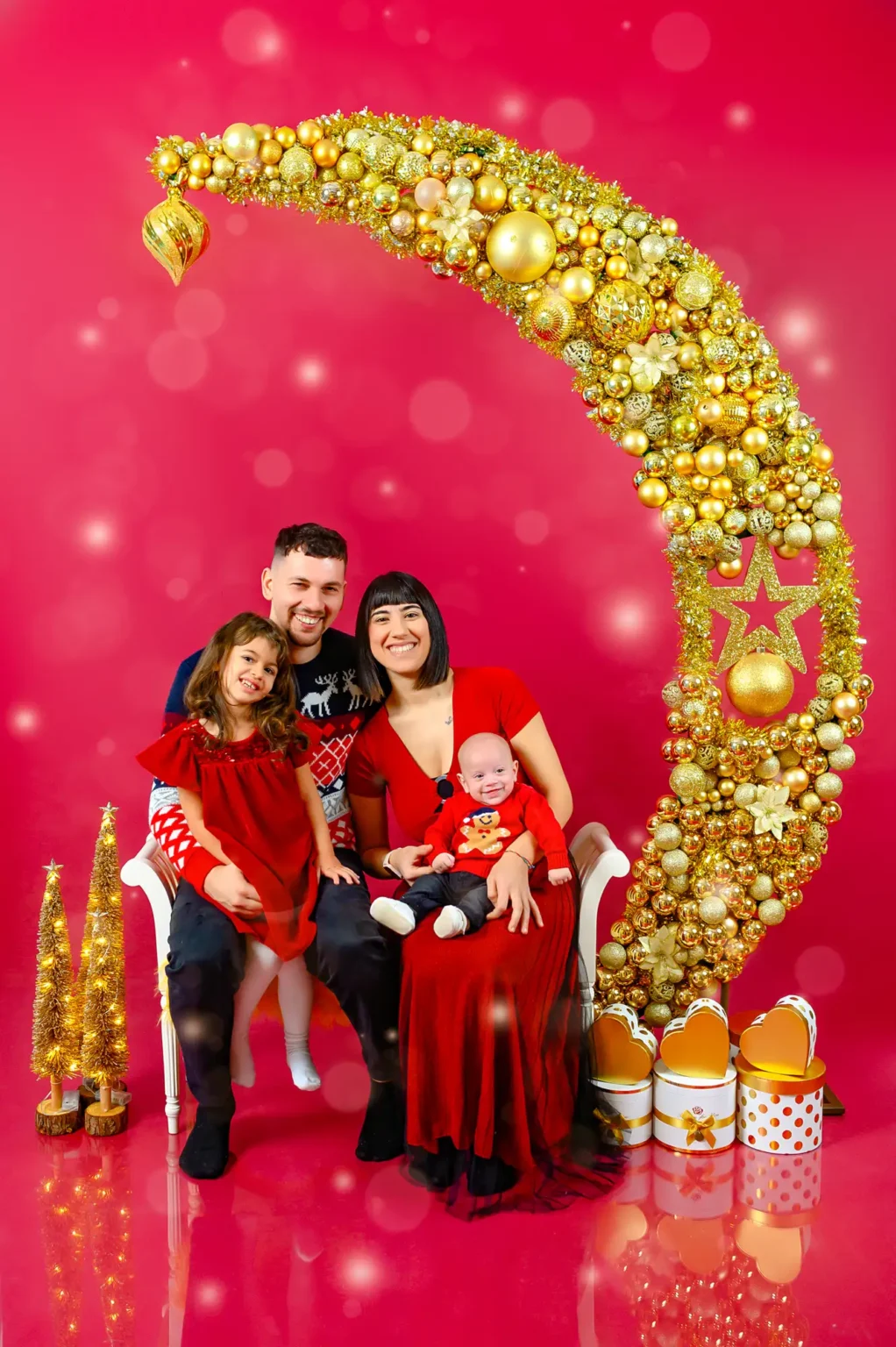 Famiglia con abiti rossi su fondale rosso e oro, ritratto di Natale in studio a Torino