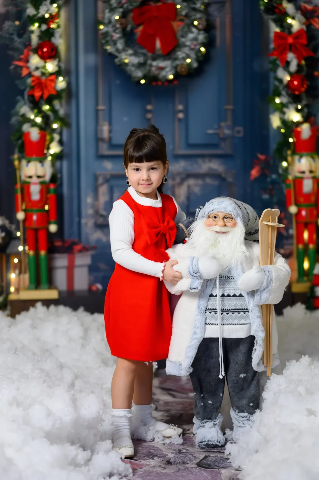 Bambina in abito rosso accanto a Babbo Natale, fotografia di Natale in studio a Torino